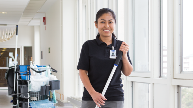Kvinnlig lokalvårdare i sjukhuskorridor.