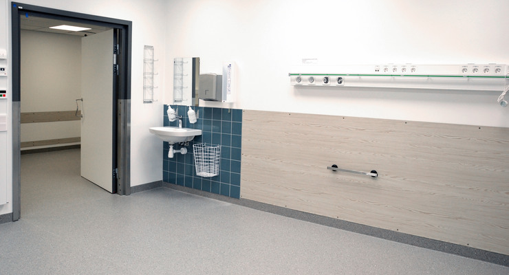 Mottagningsrum med handfat och öppen dörr.