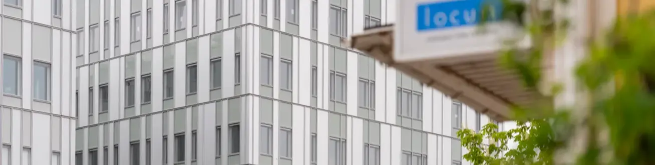 En gatuskylt framför en stor byggnad.