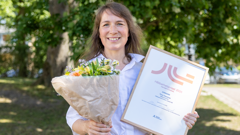 Tove Hesslow som tagit emot blommor och diplom vid prisutdelning.