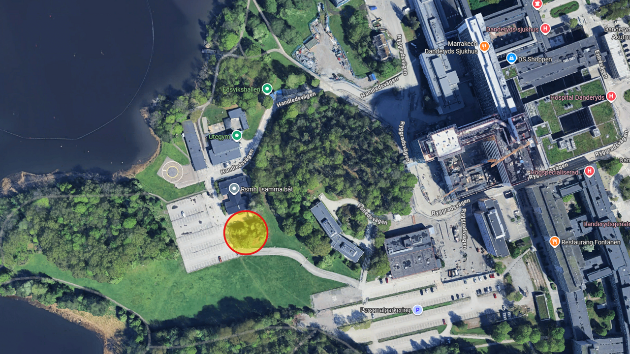 Flygfoto över del av sjukhuspark vid Danderyds sjukhus med markering för plats där det ska grävas.