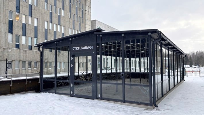 Ett cykelgarage mellan tv&aring; huskroppar.