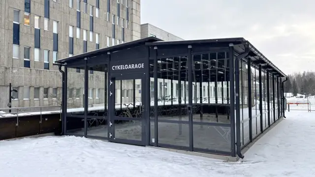 Ett cykelgarage mellan byggnader. 