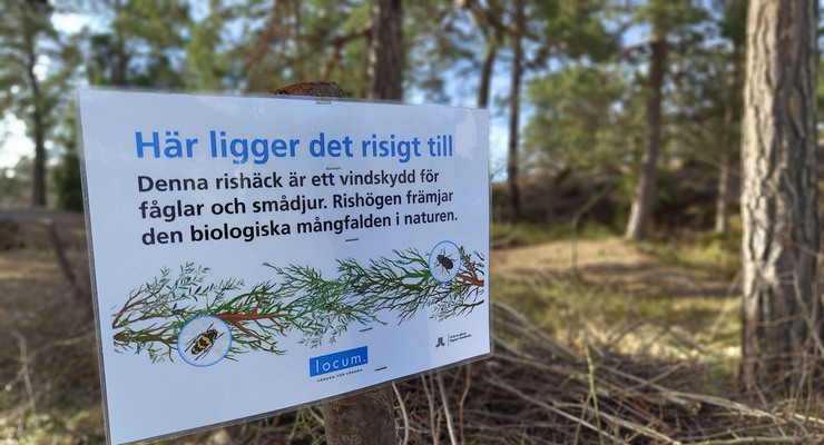 Skylt vid en rishäck som beskriver att rishäcken är ett vindskydd för fåglar och smådjur.