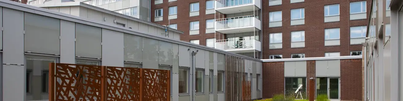 Innergård med växlighet och konst av cortenstål.