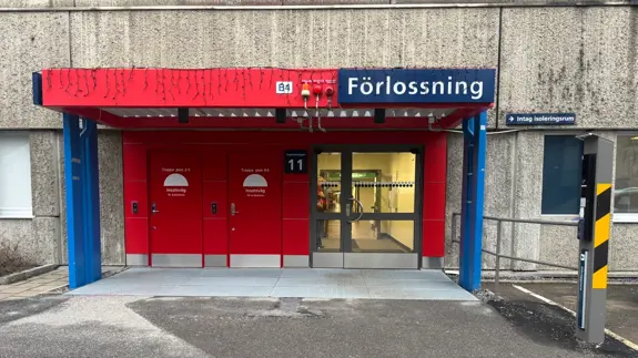 En röd och blå dörrentré in till ett sjukhus. 