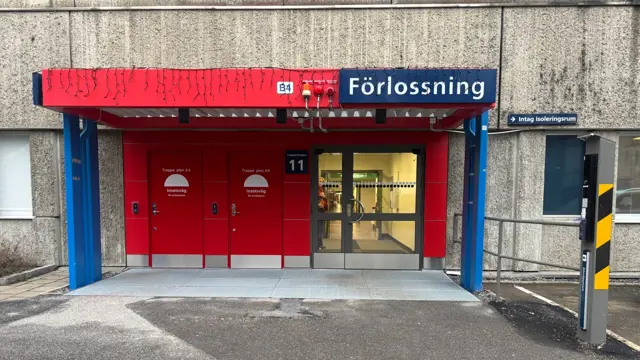 En röd och blå dörrentré in till ett sjukhus. 