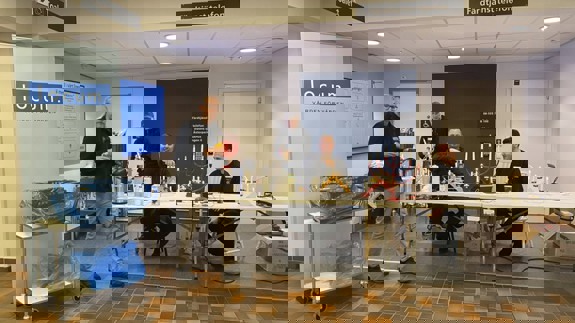 En grupp människor som sitter runt ett bord och byter ut ljus i elljusstakar.