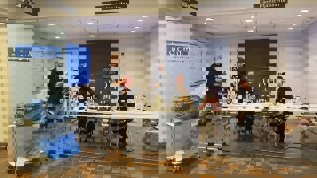 En grupp människor som sitter runt ett bord och byter ut ljus i elljusstakar.