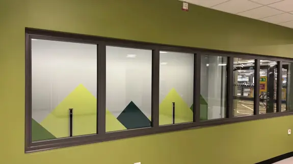 Ett rum med en grön vägg och flera fönster.