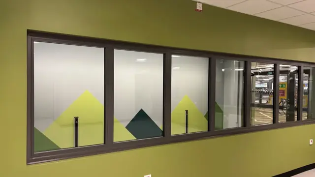 Ett rum med en grön vägg och flera fönster.