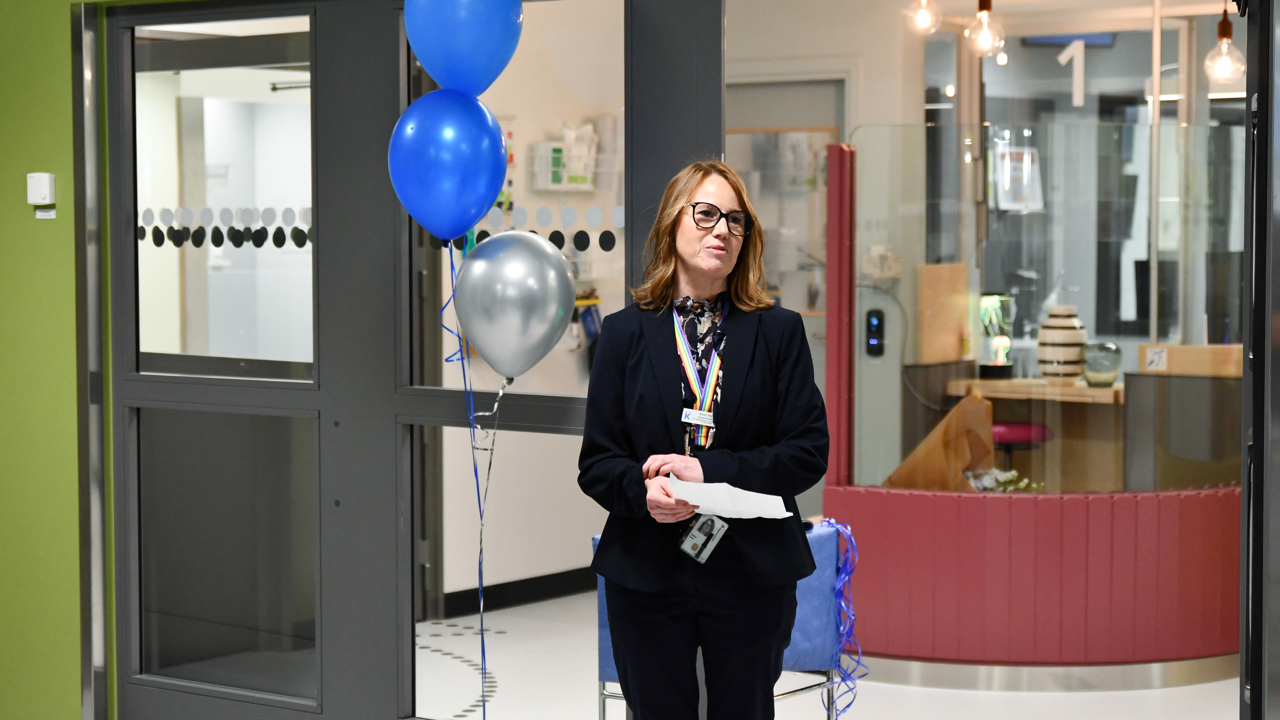 En kvinna st&aring;r framf&ouml;r en glasd&ouml;rr.