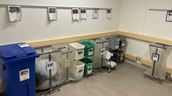 Utrymme med flera avfallskärl. 