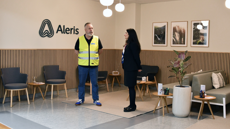 En man och en kvinna som står i ett väntrum med flera sittmöbler.