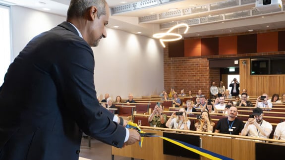 Södersjukhusets sjukhusdirektör Karouk Said klipper band och publik ser på.