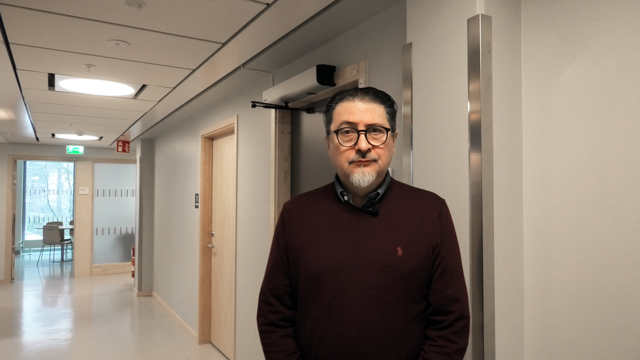 Man står i sjukhuskorridor.