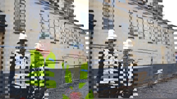 Två kvinnliga representanter från Kraftens hus står utanför G-huset under ombyggnad.