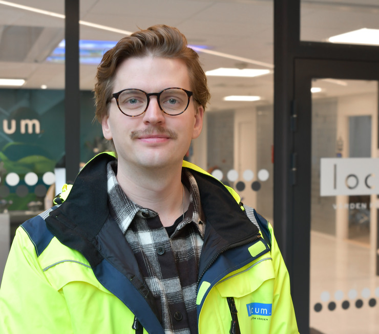 Manlig projektledare står utanför entré till Locums huvudkontor.