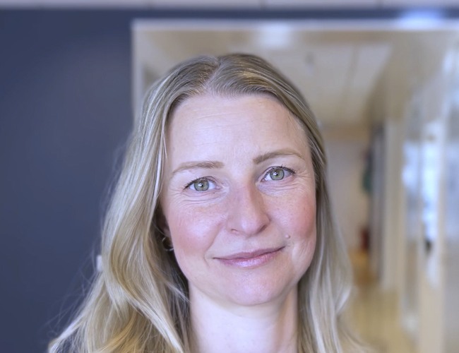 Kvinna står i en korridor.