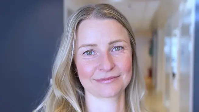 Kvinna står i en korridor.