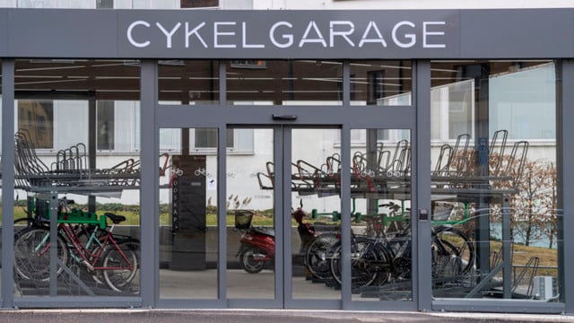Ett cykelgarage med cyklar parkerade i det.