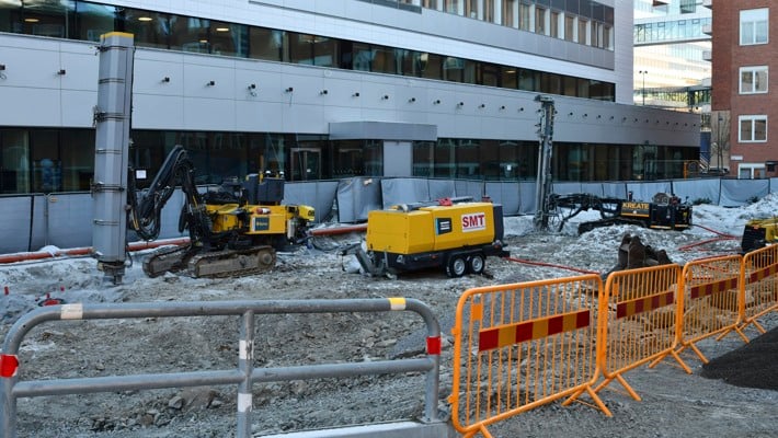 En byggarbetsplats framf&ouml;r en stor byggnad.