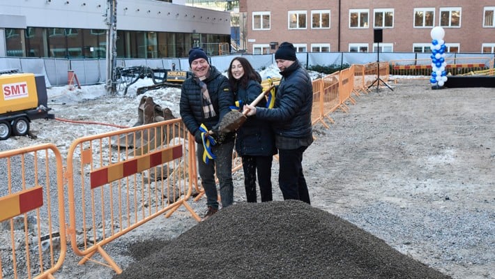 En grupp m&auml;nniskor som st&aring;r runt en jordh&ouml;g.