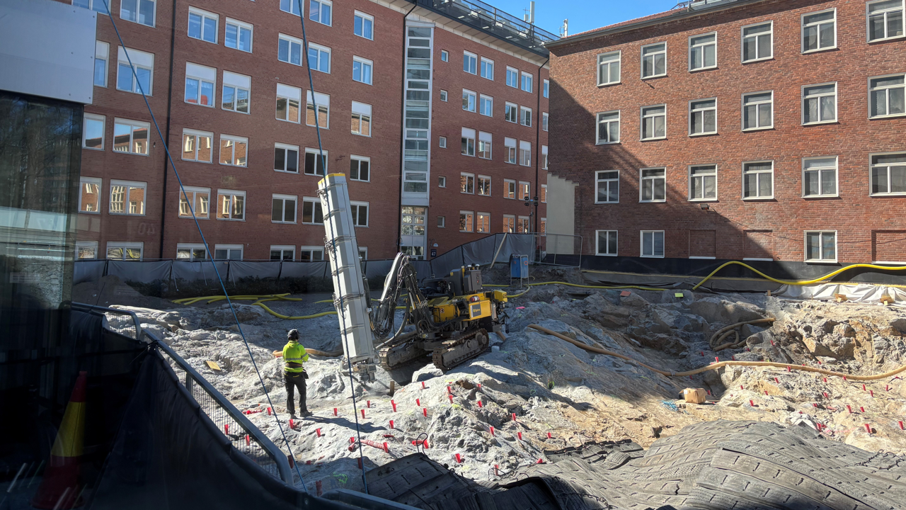 En byggarbetsplats framf&ouml;r en stor tegelbyggnad.