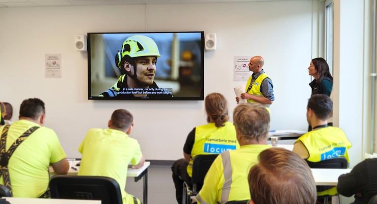 Personer i konferensrum som tittar på film under Håll Nollans säkerhetspush.