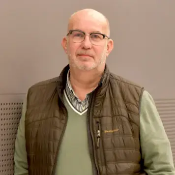 Anders Bertilsson lutad mot en brun vägg.