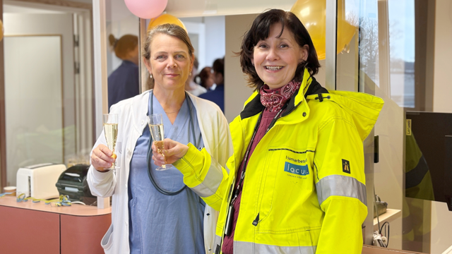 Kvinna i vårdkläder och kvinna i varseljacka under invigning av nyrenoverade lokaler, FAM, Danderyd.