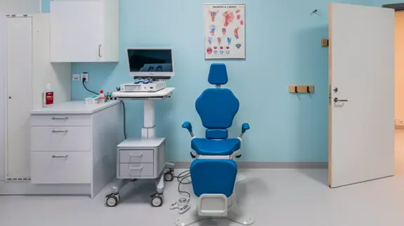 Ett rum med en blå stol och en dator.