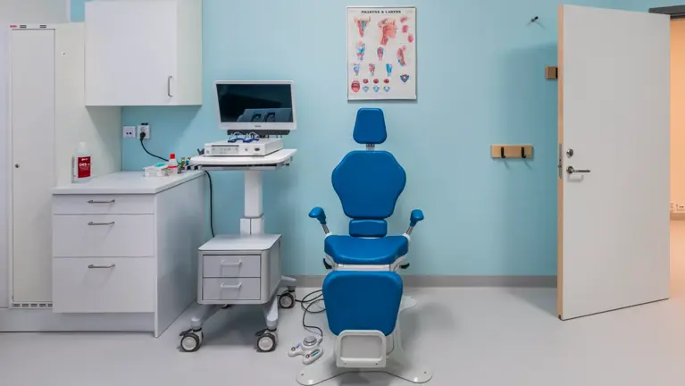 Ett rum med en blå stol och en dator.