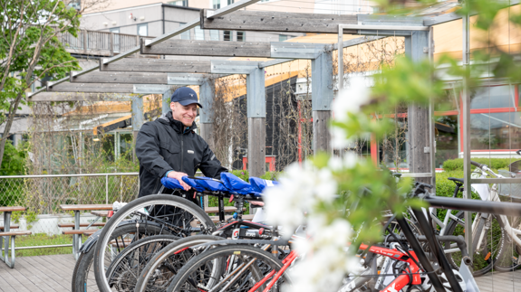 En man som står bredvid ett gäng cyklar.