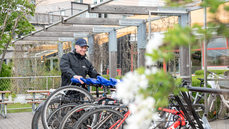 En man som står bredvid ett gäng cyklar.