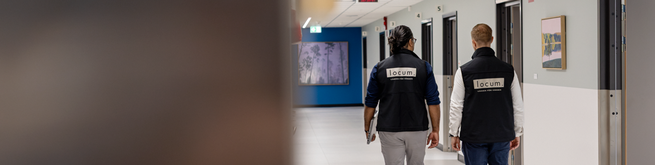Några personer som går längs en korridor.
