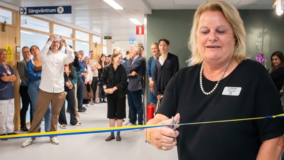 Verksamhetschef klipper band och andra tittar på.