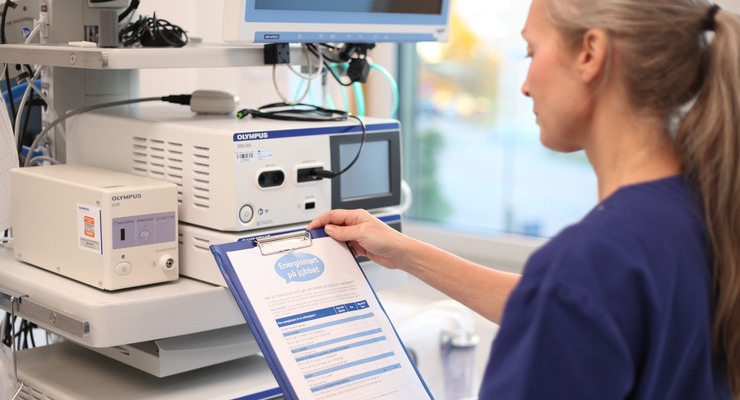 Kvinna vid medicintekniskt utrustning och checklista för elrond.