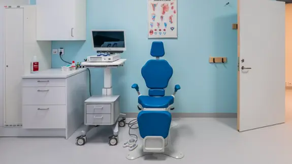 Ett rum med en blå stol och en dator.