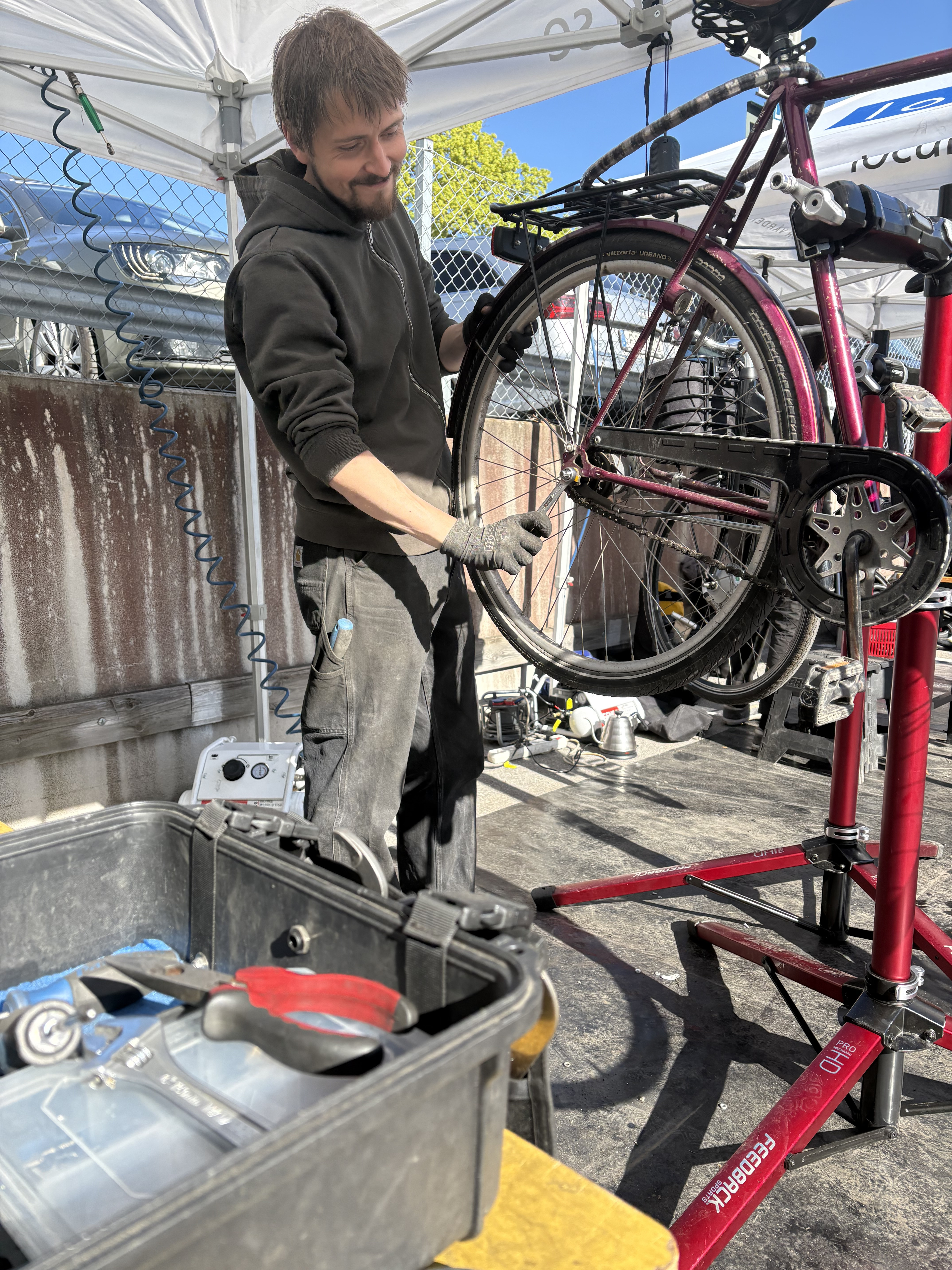 En cykelmekaniker står med en upphängd cykel.