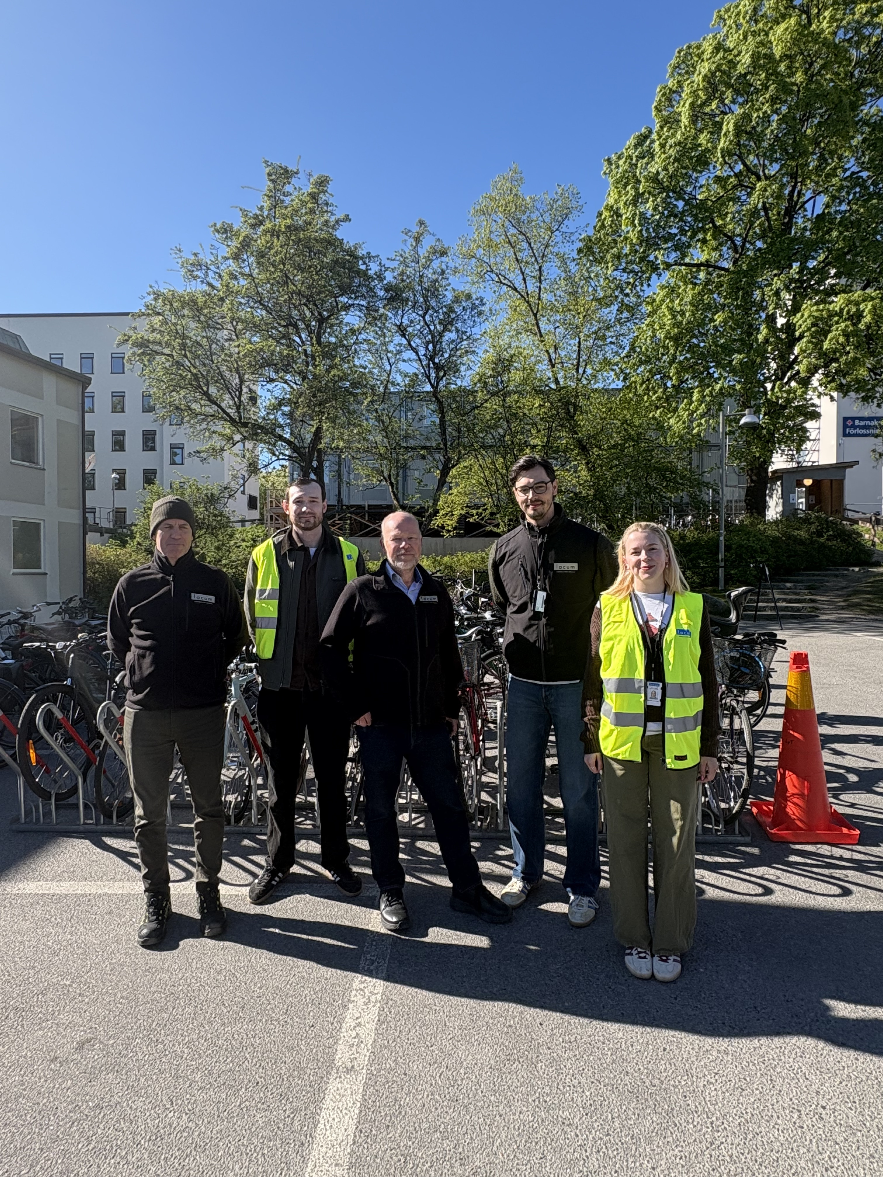 Medarbetare från Locum står framför cyklar och tittar in i kameran.