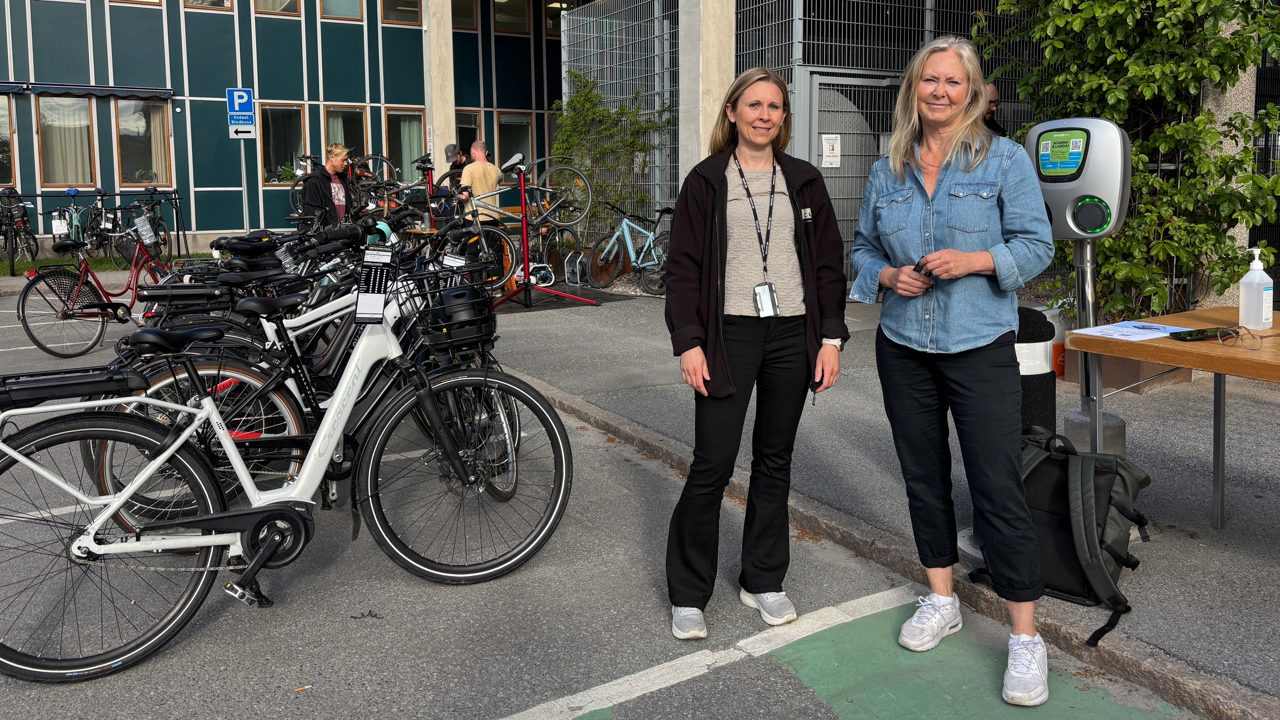Tv&aring; kvinnor bredvid ett bord och cyklar under cykeldag p&aring; Danderyds sjukhus.