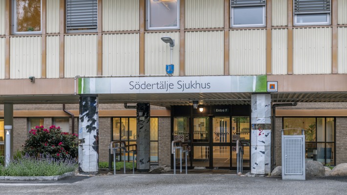 En h&ouml;g byggnad med en skylt d&auml;r det st&aring;r S&ouml;dert&auml;lje sjukhus.