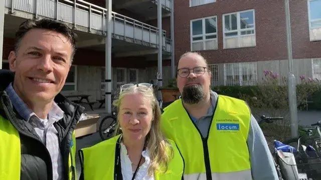 Tre locummedarbetare med gul väst står vid cyklar som ska servas.