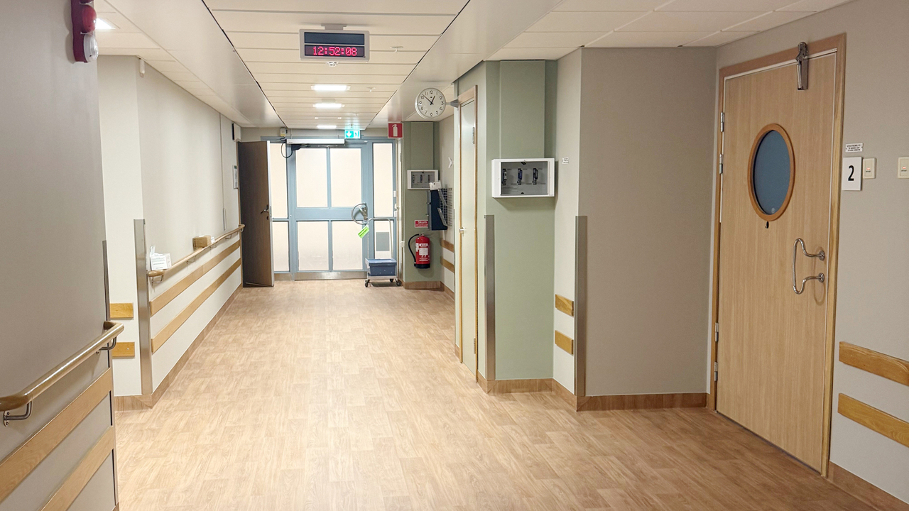 Korridor med tr&auml;f&auml;rgat golv och ljusa v&auml;ggar p&aring; f&ouml;rlossningens akutmottagning vid Danderyds sjukhus.