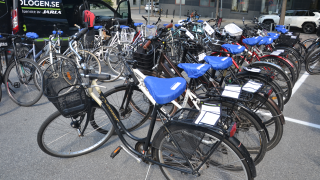 Ett gäng cyklar parkerade på en parkeringsplats.