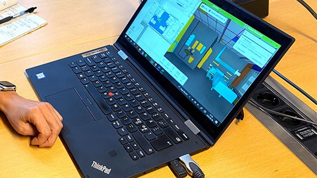 Person som visar laptop med bild på en 3D-modell av vårdrum.