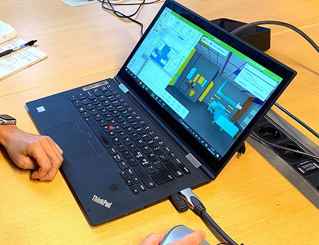 Person som visar laptop med bild på en 3D-modell av vårdrum.