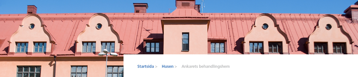 Fasad på Grimmans aprikosfärgade byggnad och orange plåttak.