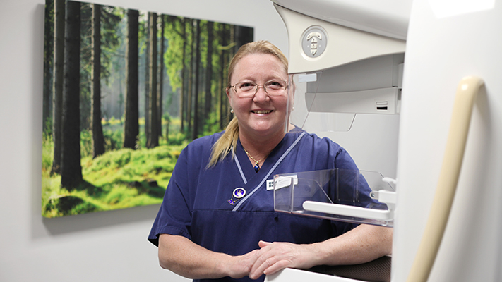 Marie Lyckman Bergman, röntgensjuksköterska på S:t Görans sjukhus står vid röntgenapparat inne på mottagningsrum. 